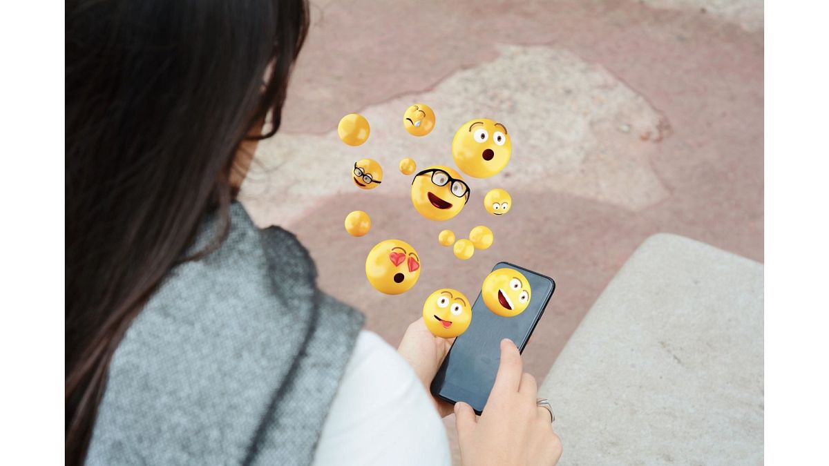 Woman using smartphone sending emojis