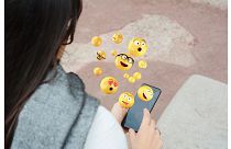 Woman using smartphone sending emojis