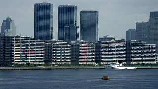 National banners hang from balconies at an athlete's village as Tokyo prepares for the 2020 Summer Olympics, Saturday, July 17, 2021. 