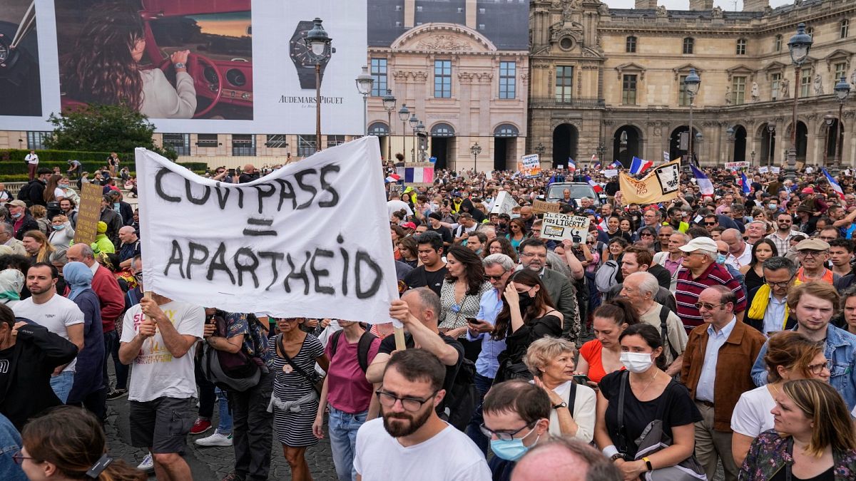 Anti-vaccine protesters holds a banner that reads health pass equal apartheid during a rally in Paris, Saturday, July 17, 2021. 