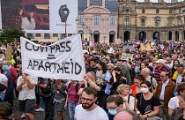 Anti-vaccine protesters holds a banner that reads health pass equal apartheid during a rally in Paris, Saturday, July 17, 2021.