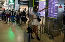 Passageira verifica lista de voos no aeroporto de Lisboa