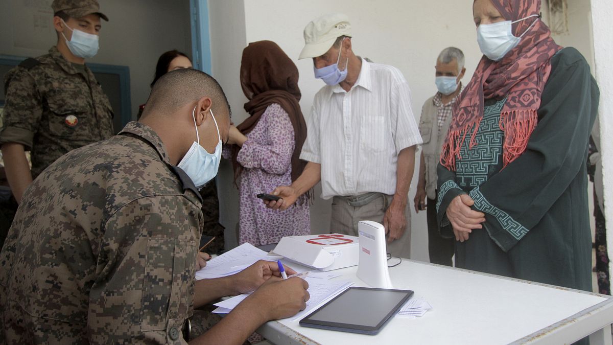 جندي يسجل أشخاصا قبل حصولهم على اللقاح في تونس 