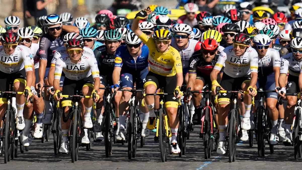 Slovenia's Tadej Pogacar, wearing the overall leader's yellow jersey,  rides with his UAE Team Emirates teammates during the last stage of the Tour de France, 18 July, 2021.  