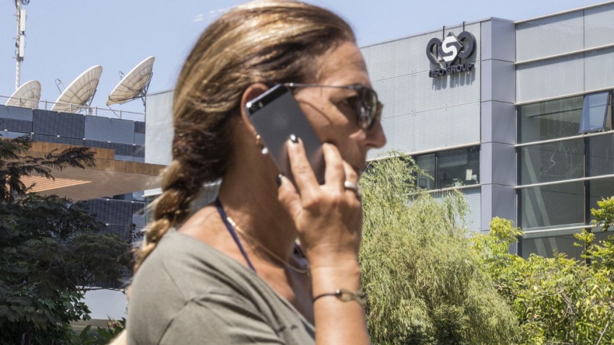 Archivo. Una mujer utiliza un teléfono frente a la sede de la firma israelí NSO, que vende el software Pegasus 