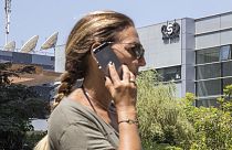 Archivo. Una mujer utiliza un teléfono frente a la sede de la firma israelí NSO, que vende el software Pegasus