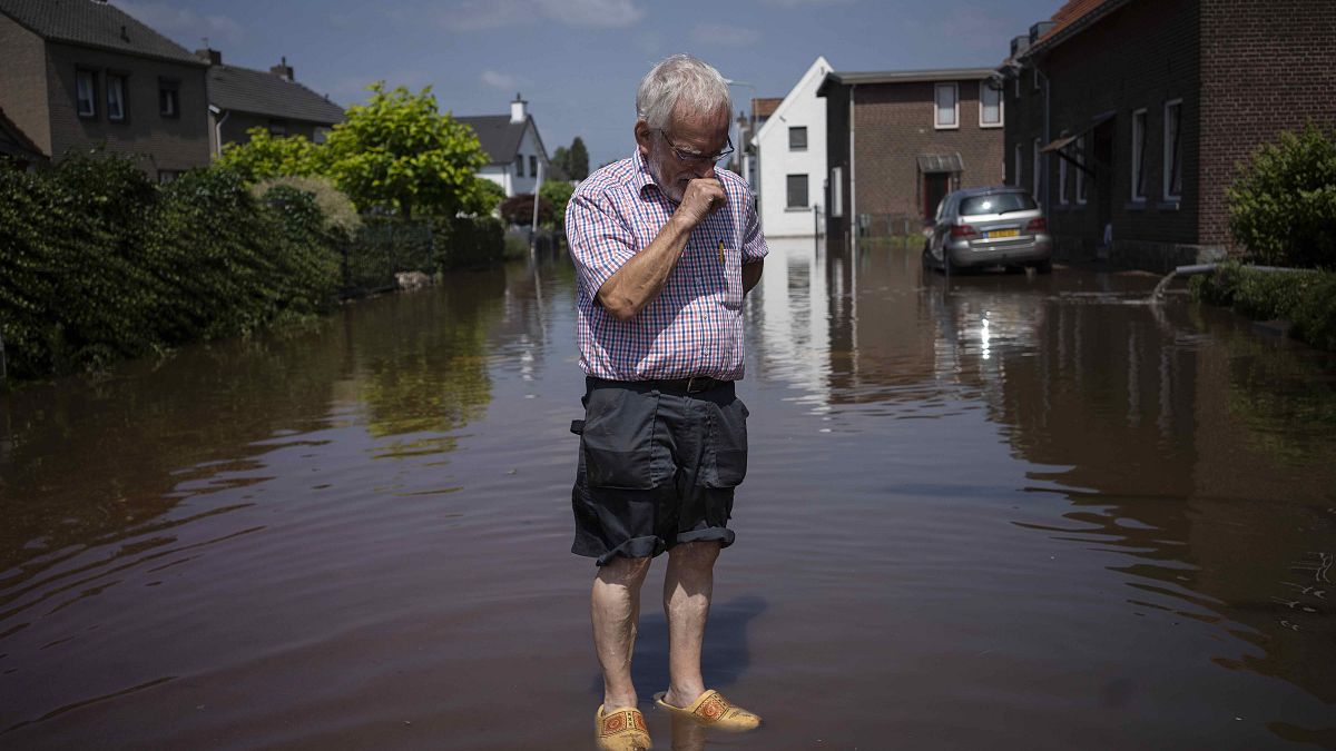 Wiel de Bie, 75, stands outside his flooded home in the town of Brommelen, Netherlands.