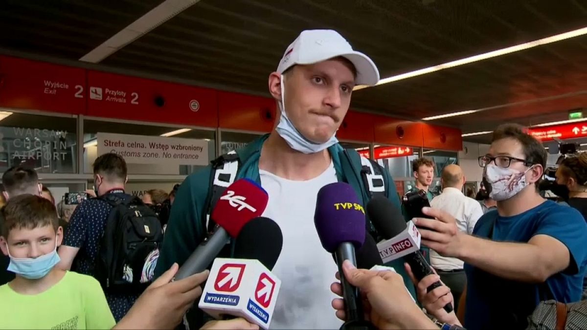 Le nageur Jan Holub répond aux questions des journalistes à l'aéroport de Varsovie-Chopin, en Pologne