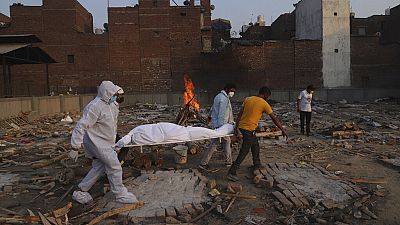 Family members and volunteers carry the body of a COVID-19 victim for cremation in New Delhi, India.