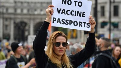 متظاهرة ترفع لافتة في لندن كتب عليها "لا لجواز السفر الصحي" 