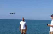 Drones are operated above the Sitges shore to monitor COVID-19 social distancing measures.