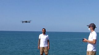 Drones are operated above the Sitges shore to monitor COVID-19 social distancing measures.