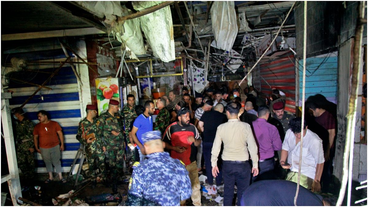 عناصر أمنية ومدنيون يتفقدون موقع التفجير الدامي الذي نفذه تنظيم الدولة الإسلامية في سوق الوحيلات بمدينة الصدر بالعراق
