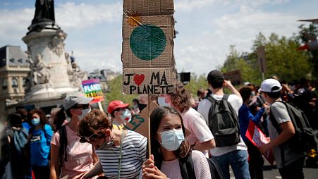A young protester holds a bord reading « I love my planet » during a rally against the climate change in Paris, Sunday, May 9, 2021. 