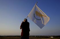 A man with a Cyprus flag stands in front of Varosha 