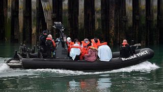 UK Border Force officials with migrants picked up in the English Channel, as they arrive in Dover, southeast England on August 15, 2020.
