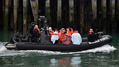 UK Border Force officials with migrants picked up in the English Channel, as they arrive in Dover, southeast England on August 15, 2020. UK Border Force officials with migrants picked up in the English Channel, as they arrive in Dover, southeast England on August 15, 2020.