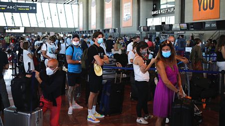 People queue in line to check-in for a British Airways flight to Heathrow airport, Friday Aug.14, 2020 at Nice airport, southern France