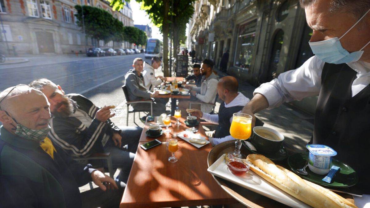 People enjoy a breakfast at a café terrace Wednesday, May, 19, 2021 in Strasbourg, eastern France.