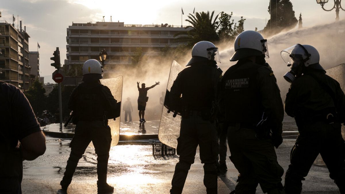 Greek police use tear gas and water cannons to disperse anti-vaccine protesters during a rally in central Athens on Wednesday