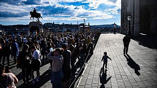 A man walks with a child in front of the parliament building in Budapest during a demonstration