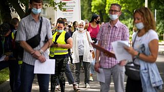 People wait in line to receive the COVID-19 jab at a Moscow vaccination centre in July