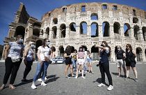 Tourists wear face masks to curb the spread of COVID-19 as they listen to a tour guide outside the ancient Colosseum, in Rome, May 21, 2021.
