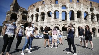 Tourists wear face masks to curb the spread of COVID-19 as they listen to a tour guide outside the ancient Colosseum, in Rome, May 21, 2021. 