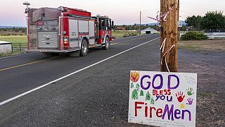 A firetruck responding to the Bootleg Fire is driven past a hand-painted sign thanking firefighters