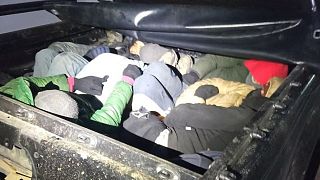 Migrants in the back of a vehicle stopped during the police operation