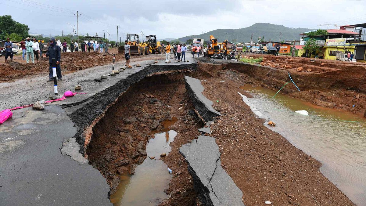 يتجمع الناس على طول جزء من الطريق السريع الذي جرفته الأمطار جزئيًا في ولاية ماهاراشترا الغربية، الهند، 24 يوليو 2021