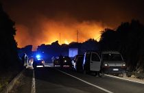 Cars are parked by the road as fires have been raging through the countryside in Cuglieri, near Oristano, Sardinia, Italy, July 25, 2021. 