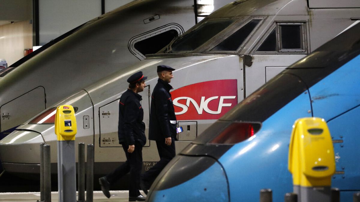 Deux agents sncf passent devant un train, à Paris, France. Archives