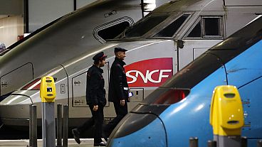 Train operator SNCF employees walk past a train at the Montparnasse train station, Paris. Dec.17, 2019. 