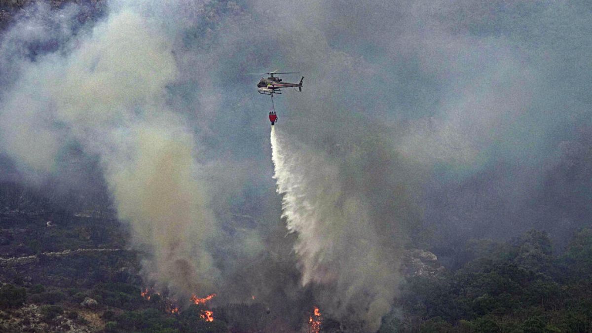 İtalya'nın Sardinya Adası'nda çıkan orman yangınına müdahale eden bir helikopter.
