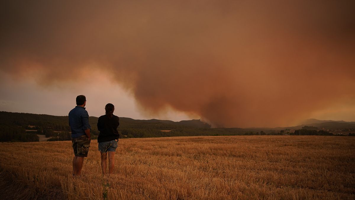 Residents look on as athe forest fire rages near Tarragona.