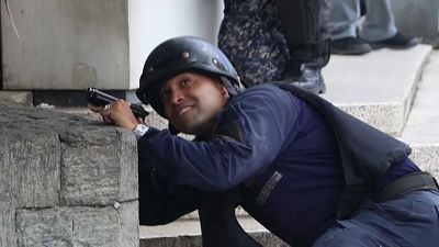 Un miembro de las fuerzas de seguridad venezolanas se protege de los disparos