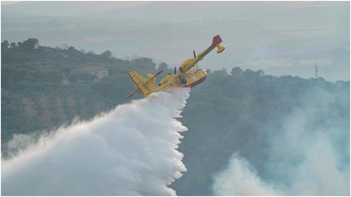 طائرة من طراز"كانداير" تلقي مواد لإخماد النيران بالقرب من منطقة أوريستانو في جزيرة سردينيا الإيطالية، الاثنين 26  تموز/يوليو 2021