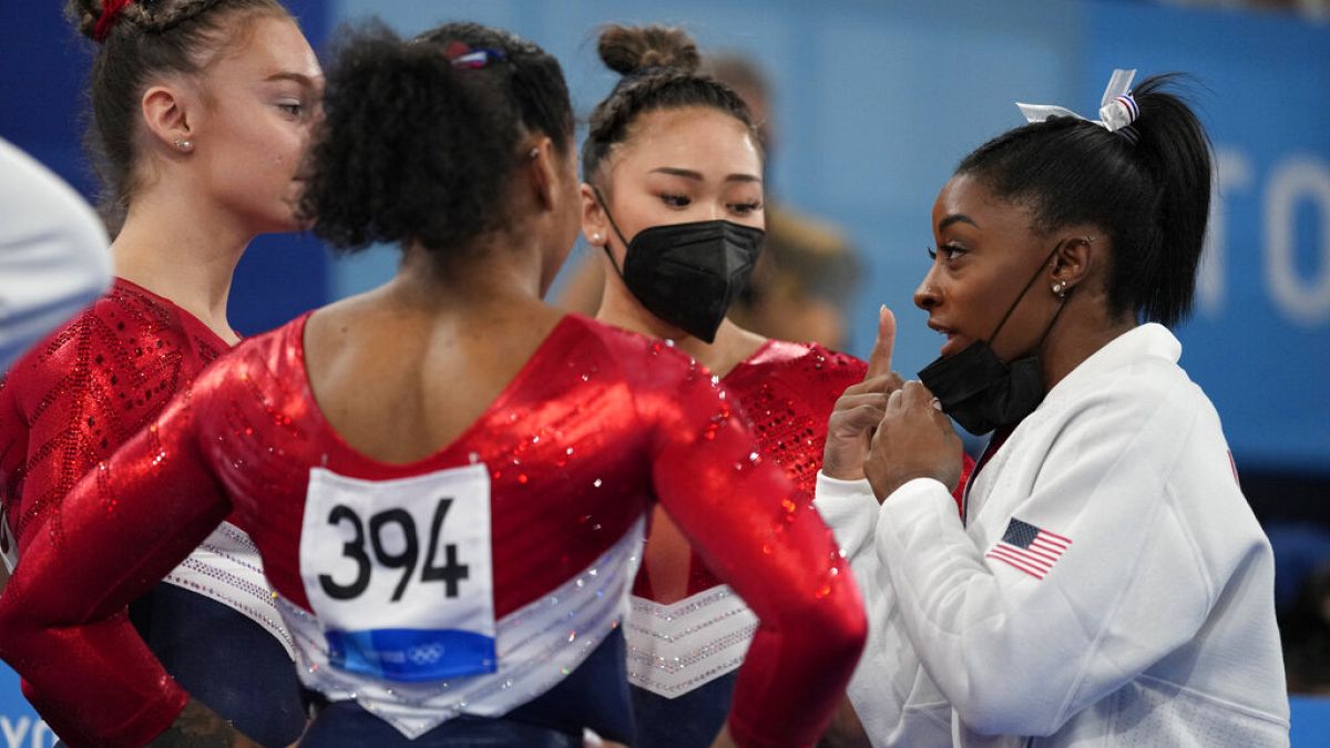 Simone Biles habla con sus compañeras del equipo estadounidense de gimnasia
