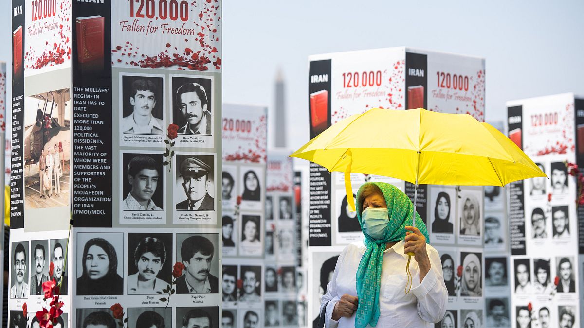 FILE: A woman walks past some of the thousands photos of people killed in Iran during the 1988 massacre of political prisoners, Washington DC, Sept. 2020. 