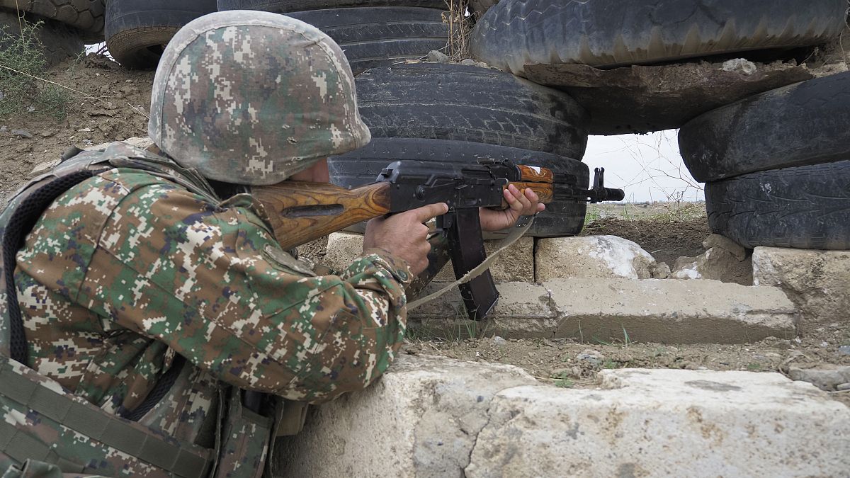 Un soldado armenio sostiene una ametralladora Kalashnikov mientras mira hacia las posiciones de Azerbaiyán