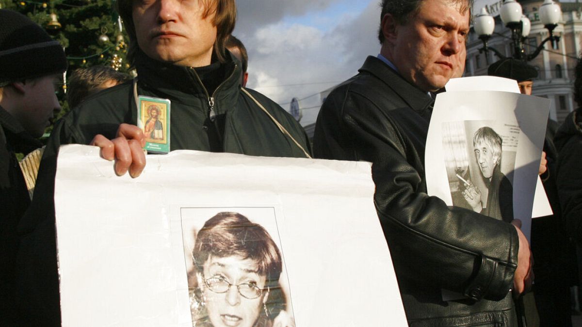 un manifestante tiene un ritratto di Anna Politkovskaya durante una manifestazione non autorizzata del 2006 per commemorare i giornalisti uccisi in Russia