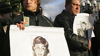 un manifestante tiene un ritratto di Anna Politkovskaya durante una manifestazione non autorizzata del 2006 per commemorare i giornalisti uccisi in Russia