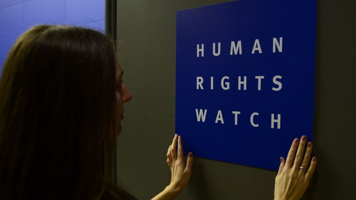  سيدة تضع شعار منظمة هيومن رايتس ووتش الحقوقية قبل مؤتمرها الصحفي لإصدار تقريرها العالمي السنوي في 21 يناير / كانون الثاني 2014 في برلين