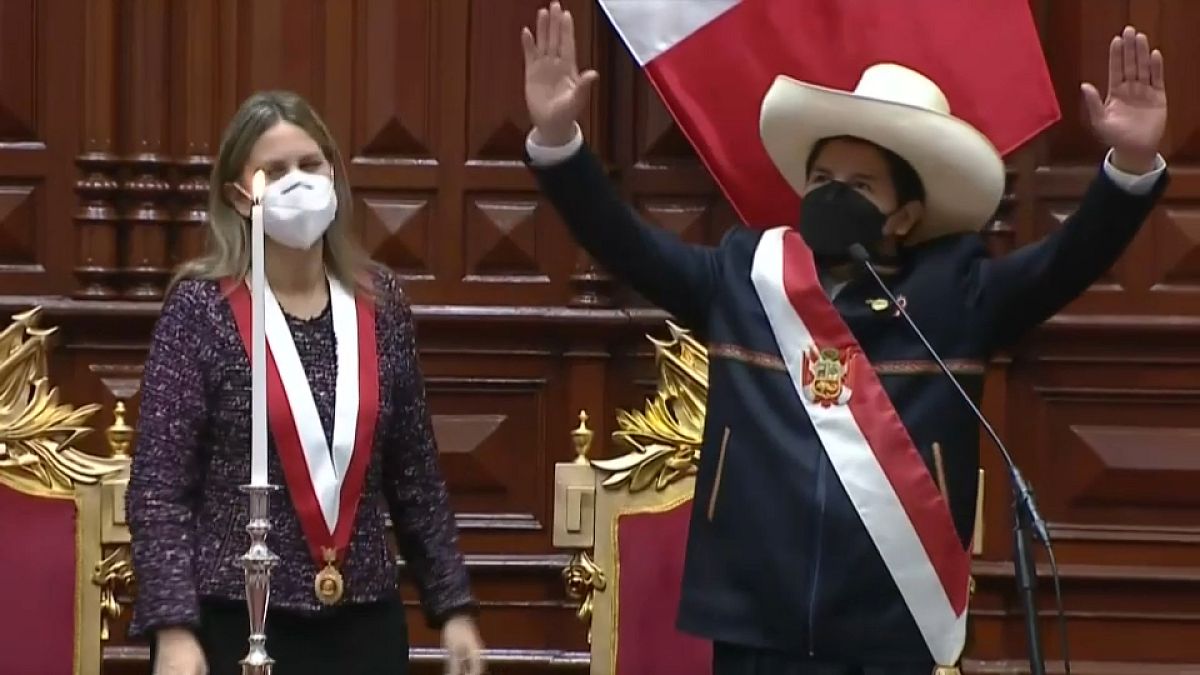 Pedro Castillo saluda tras recibir la banda presidencial de manos de la Presidenta del Parlamento