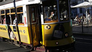 A tram conductor wearing a face mask drives through Lisbon's Graca neighborhood, Monday, July 26, 2021.