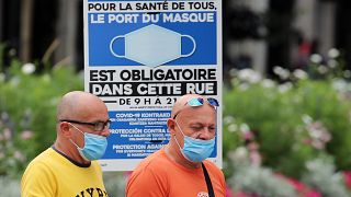 Dos hombres con mascarilla en exterior en Francia tras la reimposición de restricciones