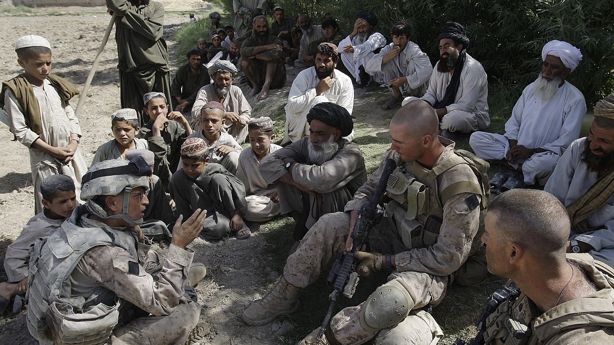 جوش حبيب، أقصى اليسار، مترجم لدى قوات المارينز الأمريكية، يتحدث مع القرويين الأفغان واثنين من مشاة البحرية في منطقة ناوا بمقاطعة هلمند بأفغانستان.