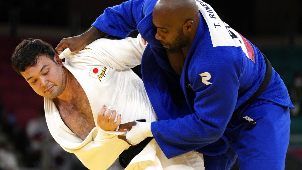 Aaron Wolf of Japan, left, and Teddy Riner of France compete during their gold medal match in team judo competition at the 2020 Summer Olympics, Saturday, July 31, 2021,.