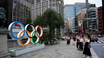 الناس يلتقطون صوراً للحلقات الأولمبية في طوكيو يوم الاثنين 19 أغسطس 2019